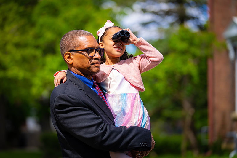 A man carrying a girl with binoculars. Links to Gifts of Appreciated Securities A man carrying a girl with binoculars. Links to Gifts of Appreciated Securities