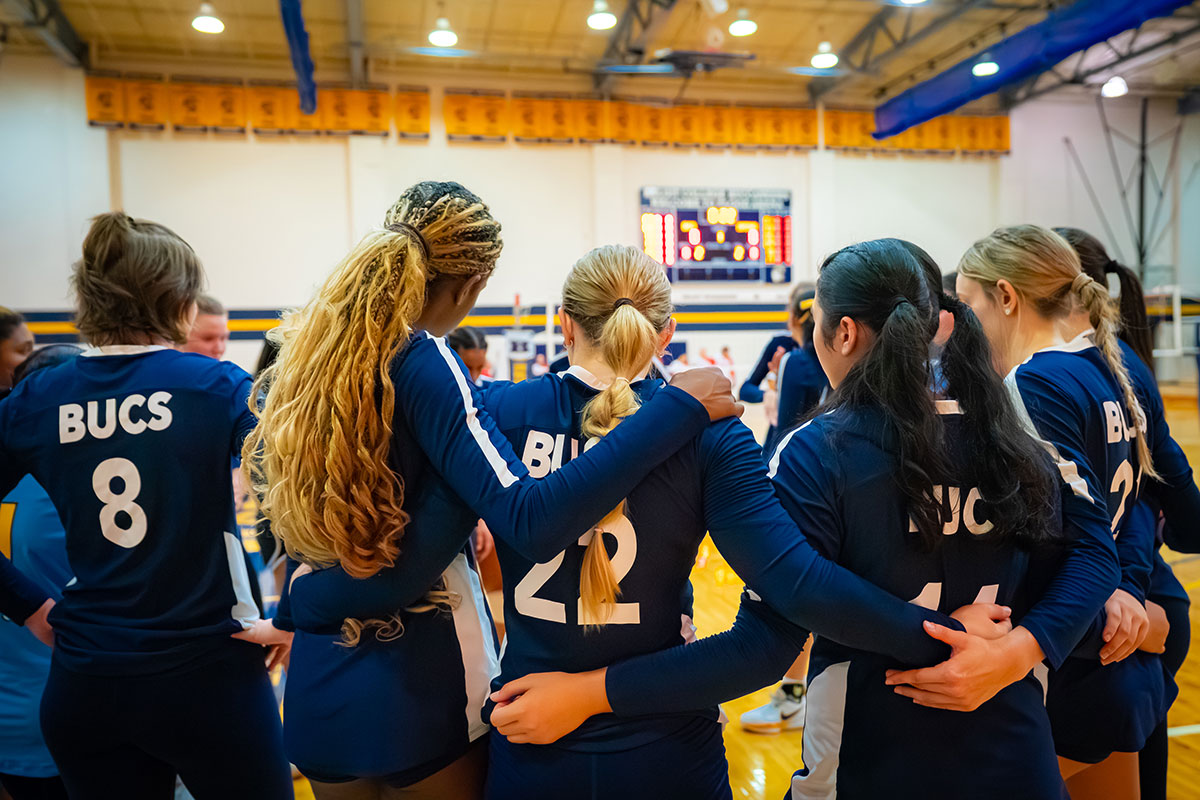 Girls on a sports team huddling together before the next round